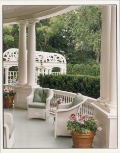 SUMMER SETTING. The classic semicircular veranda shown with white wicker furniture, coupled with a sage green wood floor that was completely redone during the six-month renovation project before the Gores moved in. Pictured also is the new pergola that leads to the pool installed by the Quayles during their stay. Number One Observatory Circle, the official home and residence of the Vice President of the United States. (Photographer: Oberto Gili). Text credit: Charles Denyer.